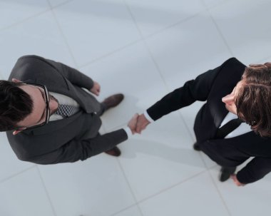 İki iş adamı ofiste el sıkışıyor.