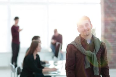 Kendine güvenen genç adam ofis arka planda.