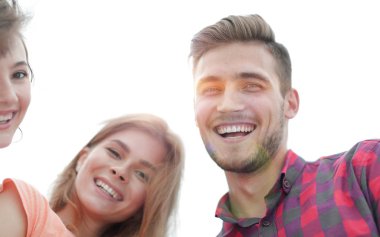 Beyaz arka planda gülümseyen üç genç insana yakın çekim