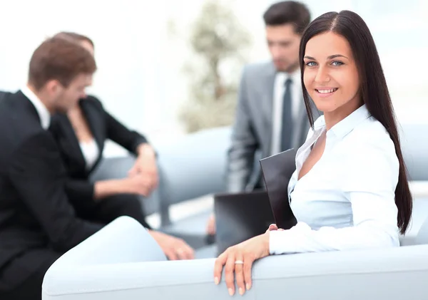 Junge Geschäftsfrau sitzt im Büro im Hintergrund Business-Team — Stockfoto