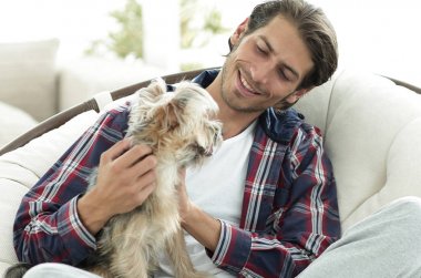 yakışıklı olan büyük bir koltukta oturan bir köpekle.