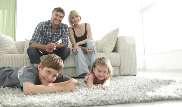 Retrato de familia feliz sentados juntos en la sala de estar —  Fotos de Stock