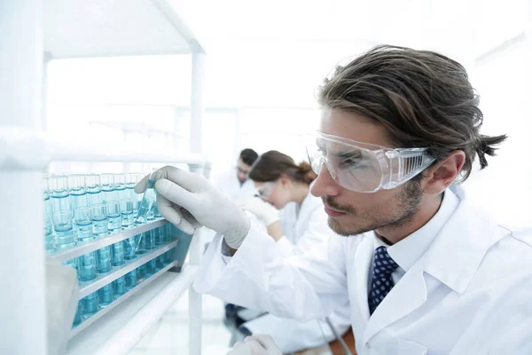 Лаборант в очках и халате с пробиркой — стоковое фото