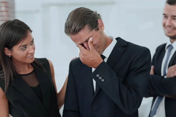 Young businessman with tears of joy and his business team — Stock Photo, Image