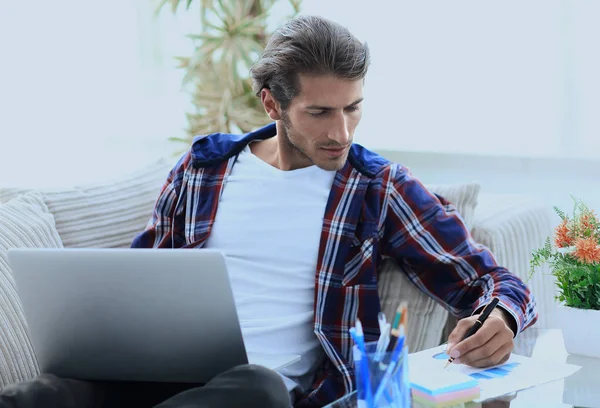 Selbstbewusster Typ, der zu Hause mit Laptop arbeitet. — Stockfoto