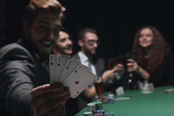 Hazardzista człowiek siedzi przy stole z karty i żetony kasyna — Zdjęcie stockowe