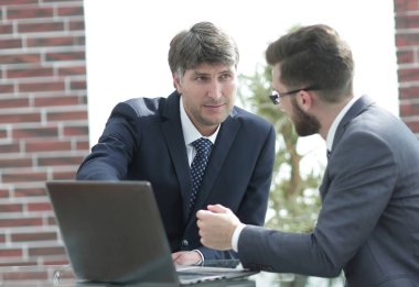 İki işadamları birlikte iş toplantı ofiste dizüstü kullanarak çalışma