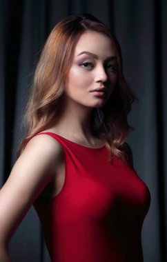 Siyah bir arka plan üzerinde poz Kırmızı elbiseli çekici esmer.