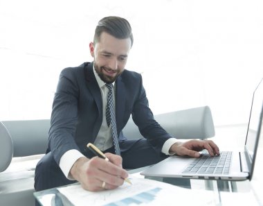 Dizüstü bilgisayarda çalışan ve Notlar not defterinde yapma şık adam