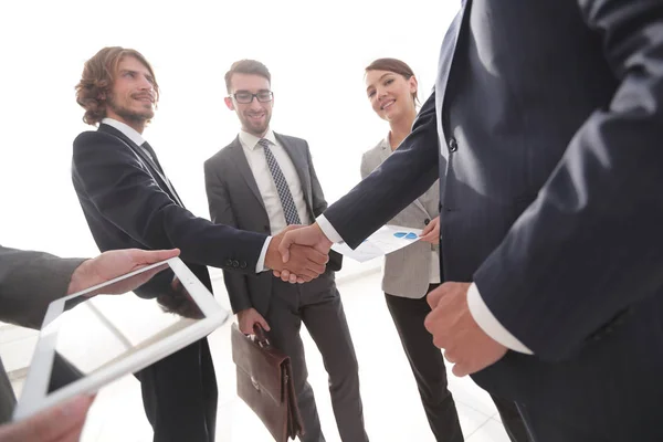 Anställda ser på de handshake affärspartnerna — Stockfoto