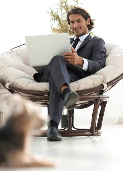 Homme d'affaires réussi avec ordinateur portable assis dans un grand armchai confortable — Photo