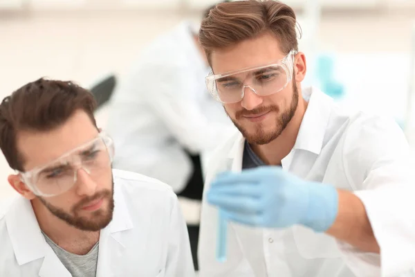 Två forskare att undersöka vätskan i ett provrör — Stockfoto