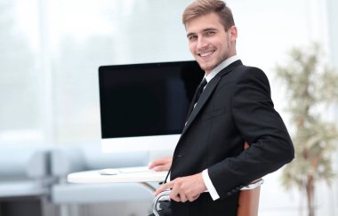 Masada oturan ve kameraya bakarak başarılı iş adamı.