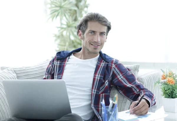 Selbstbewusster Typ, der zu Hause mit Laptop arbeitet. — Stockfoto
