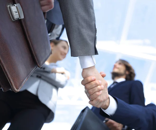 Equipo mirando a un socio de apretón de manos . — Foto de Stock