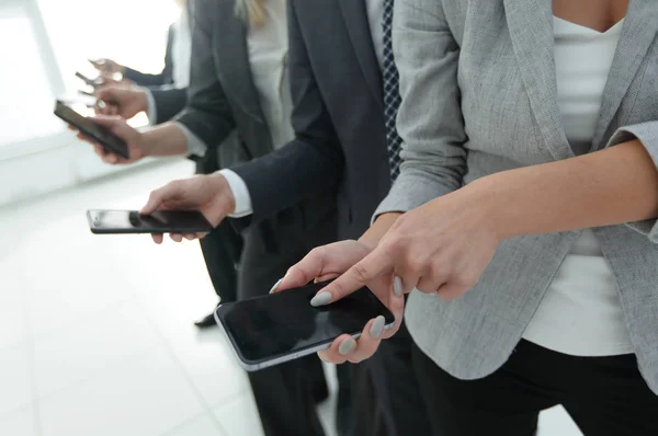 Closeup.a grupo de empleados con teléfonos inteligentes — Foto de Stock