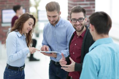 Tablet bilgisayarlı iş ekibi ofiste tartışıyor