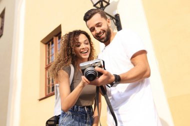 Fotoğraflara bakarak yürüyen genç arkadaşların portresi