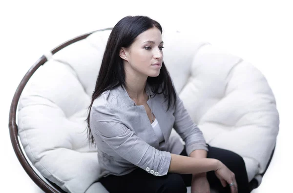 Jonge vrouw zitten in een ronde zachte gezellige grote stoel. — Stockfoto