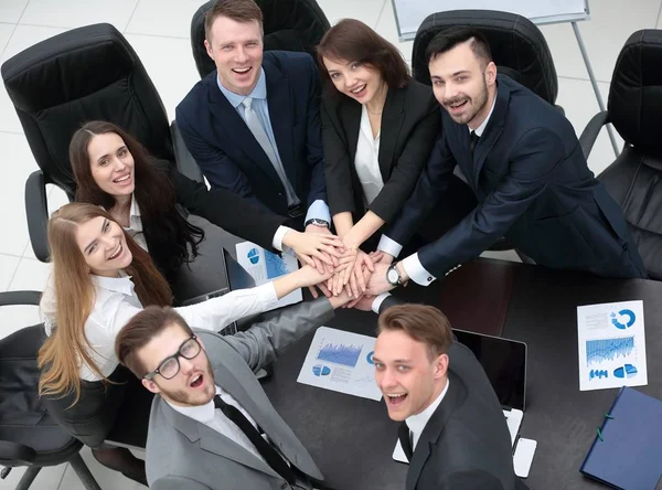 Geschäftsteam mit auf dem Schreibtisch zusammengefalteten Händen — Stockfoto