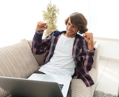 mutlu adam kanepede oturan dizüstü bilgisayar ile. başarı kavramı