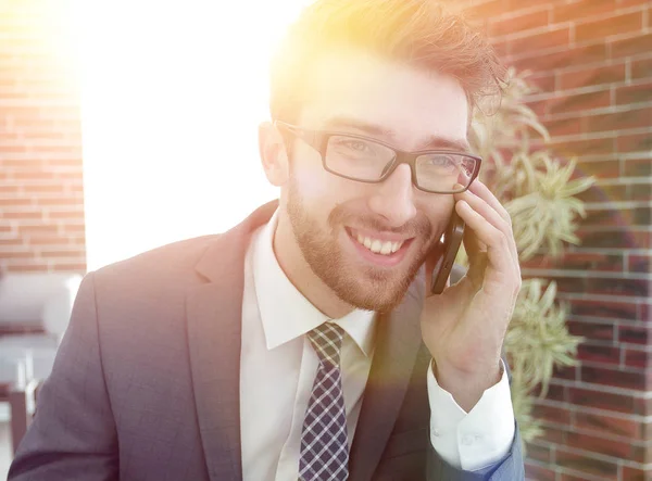 Homem de negócios falando no telefone inteligente no escritório moderno — Fotografia de Stock