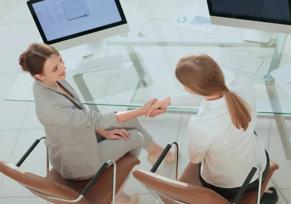 View from the top.business woman shakes hands with the officer sitting near the desktop — Stock Photo, Image