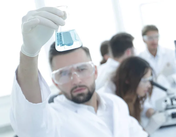 Bioquímico con frasco Petri sentado en un escritorio — Foto de Stock