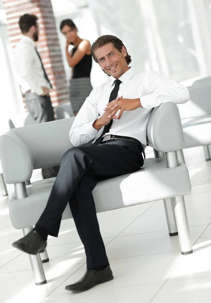 Smiling businessman sitting in office chair — Stock Photo, Image