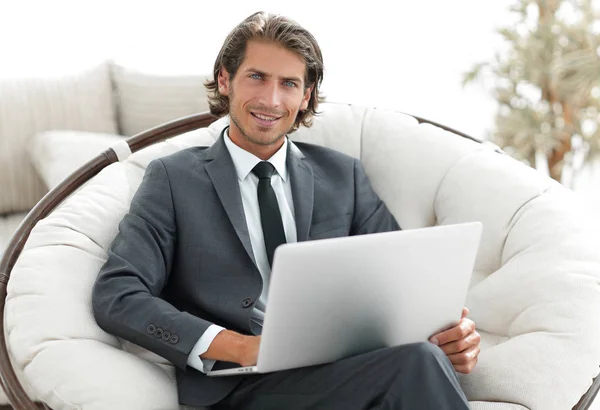 Homme d'affaires avec un ordinateur portable assis dans un chai confortable élégant — Photo