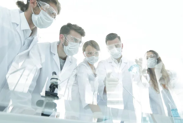 Wissenschaftler arbeiten mit Reagenzgläsern und Mikroskop im Labor — Stockfoto