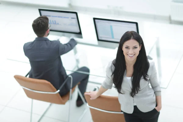 Mujer de negocios exitosa de pie cerca del lugar de trabajo moderno —  Fotos de Stock