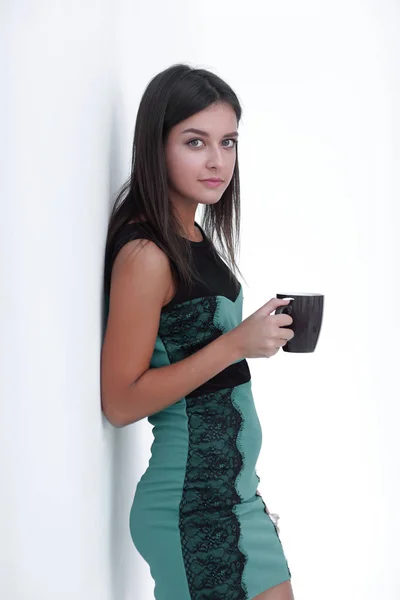 Mujer con taza de café apoyada en la pared . — Foto de Stock