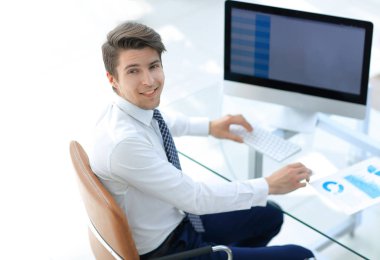 çalışan bir bilgisayar ekranı önünde oturan