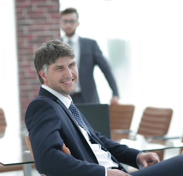 Businessman sitting in an empty conference room — Stock Photo, Image