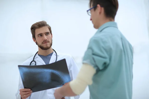 Cirujano ortopédico que examina una radiografía del paciente — Foto de Stock