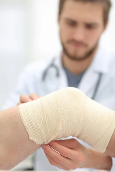 Nahaufnahme eines Arztes, der das verletzte Bein des Patienten untersucht — Stockfoto