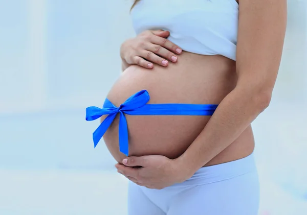 Щаслива вагітна жінка вимірює її животик і талію . — стокове фото