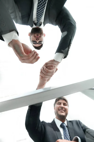 Blick von unten. hinter dem Glas. Händedruck von Geschäftspartnern — Stockfoto