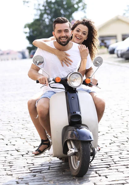 Счастливая молодая пара катается на скутере по городу в солнечный день — стоковое фото