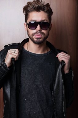 Güneş gözlüklü adam portresi. Gözlük tarafında holding