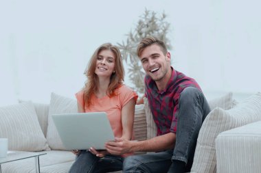 Gülümseyen çift evde dinleniyor, kanepede oturuyor..