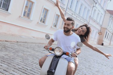 mutlu genç bir çift bir scooter üzerinde eğleniyor
