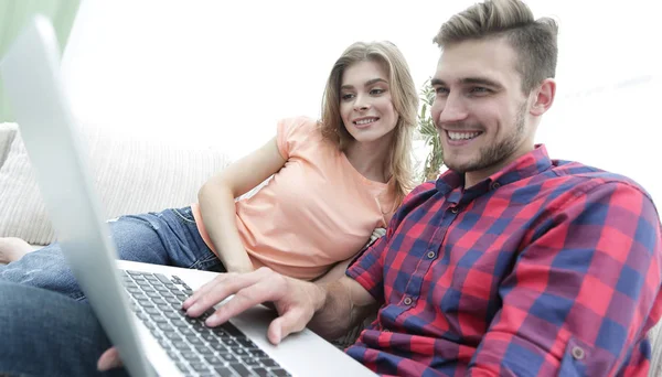 Feliz pareja moderna navegando por la red y trabajando en el ordenador portátil en casa — Foto de Stock