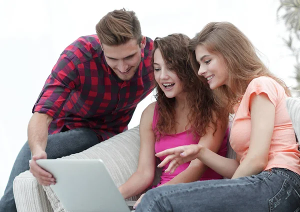 Grupp elever tittar på en laptop skärm, sitter i soffan — Stockfoto