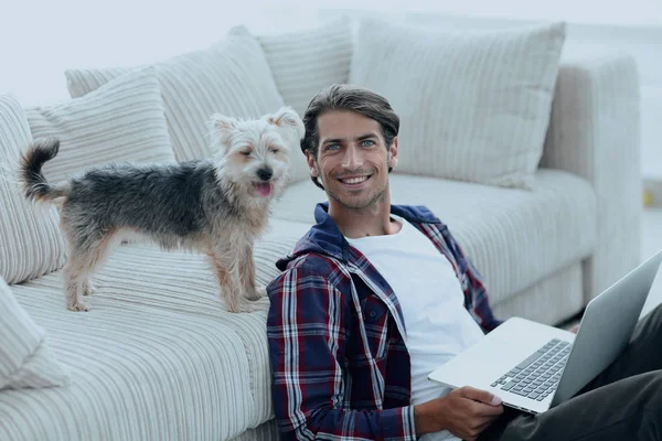 Framgångsrik kille och hans sällskapsdjur i ett mysigt vardagsrum. — Stockfoto