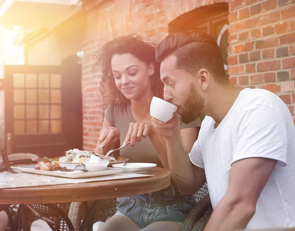 Porträt eines schönen romantischen Paares, das in einem Café mit Kaffee sitzt — Stockfoto