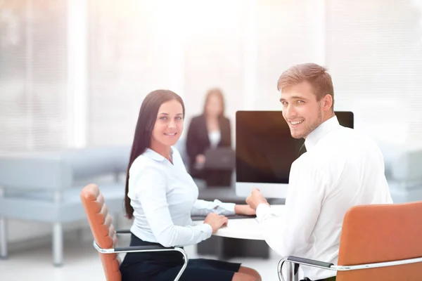 Miembros del equipo de negocios sentados en el escritorio y mirando a la cámara  . —  Fotos de Stock