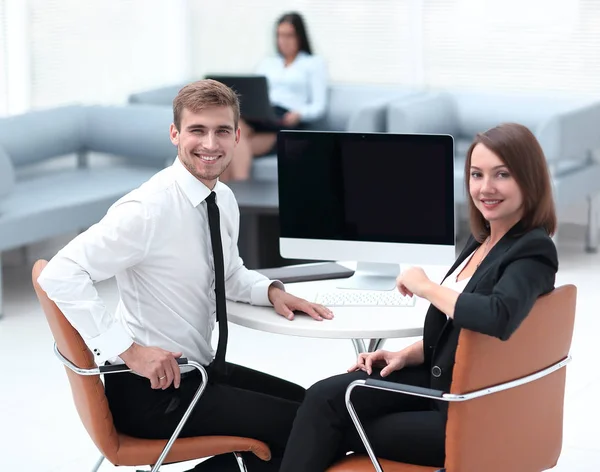 坐在办公桌前的商业团队中微笑的成员 — 图库照片
