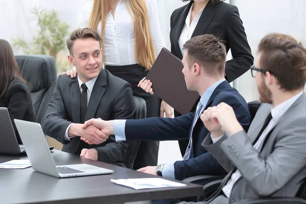 Handshake obchodních partnerů za stolem — Stock fotografie
